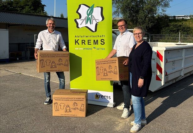 Drei Personen stehen mit den Kartonagen für die Altkleidersammlung am ASZ der Stadt Krems.