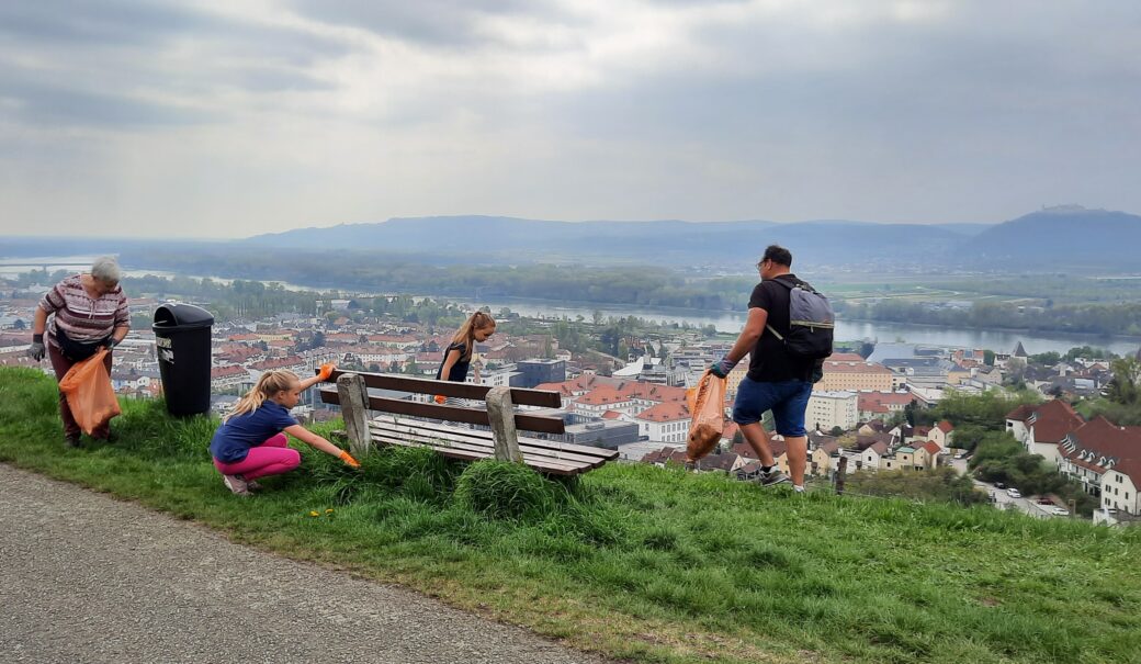 Familie beim Müllsammeln in den Weingärten oberhalb von Krems mit Blick auf die Donau